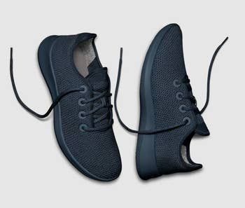 A pair of fashionable, breathable navy blue sneakers with laces, shown from both the top and side views.