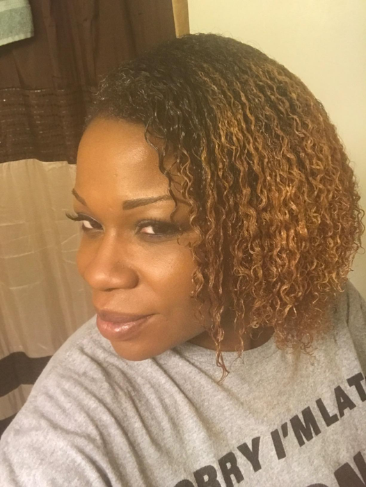 A user revealing their curly hair after using the detangling brush
