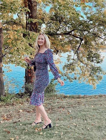 A reviewer wearing the blue floral smocked dress