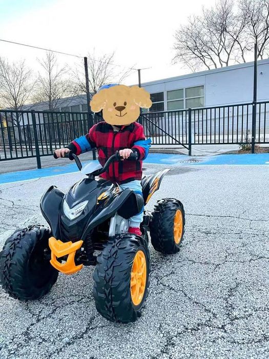 A child riding the black and yellow ATV, as shown in the review.