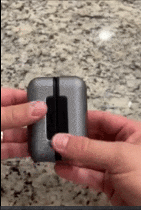 Reviewer separating two pieces of a compact square hand warmer and pressing the control buttons to adjust settings.