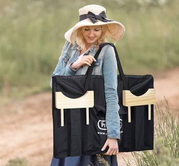 A model is shown holding the carrying bag for the connect four game, ready for transport.