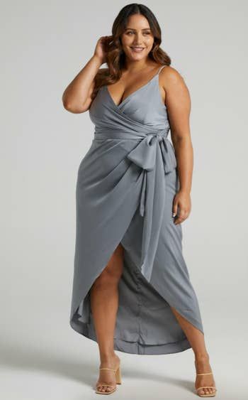 A model showcasing the dusty blue gown, featuring a bow tied at the front