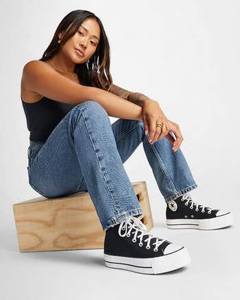 Model showcasing black platform Converse