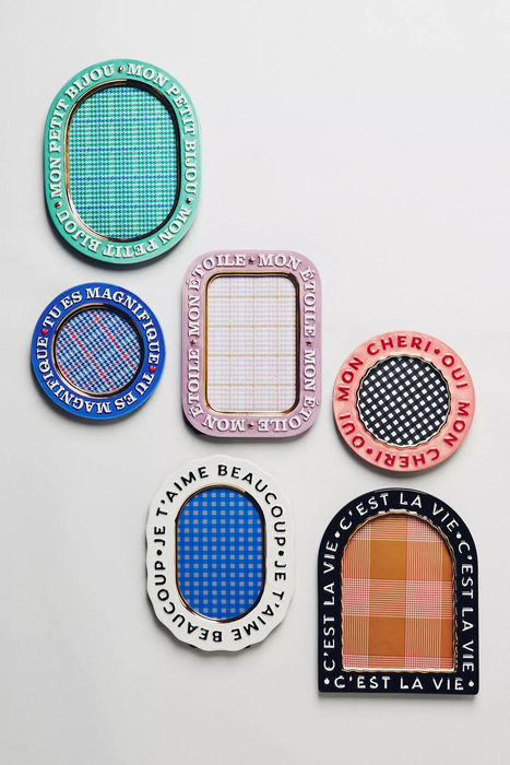 Six decorative plates featuring checkered designs and French phrases like 