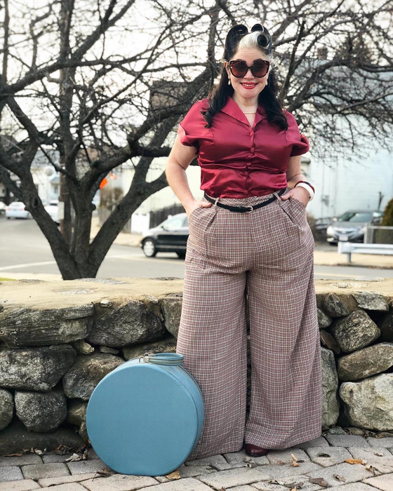 Reviewer wearing the brown plaid pants paired with a red top