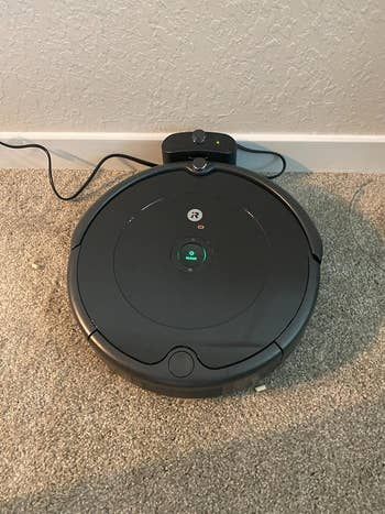 A reviewer showcases a close-up of the iRobot Roomba vacuum.