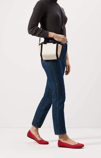 model wearing the bright red flats styled with jeans