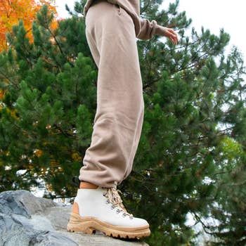 A model wearing the hiking boots in white, highlighting their style and functionality.