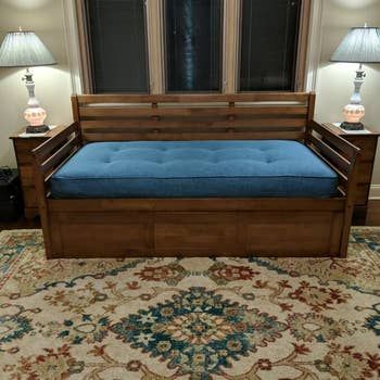 A reviewer’s photo displaying a wooden daybed.