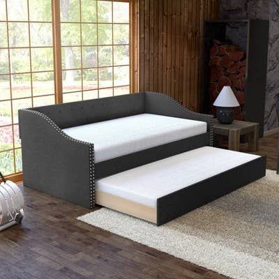 A lifestyle image featuring a black tufted upholstered trundle bed.