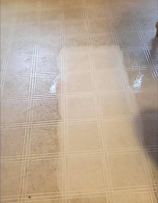 A reviewer demonstrates cleaning a tile floor with the eraser sponge.