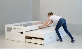 A model demonstrating how to transform the trundle bed into a king-sized bed.