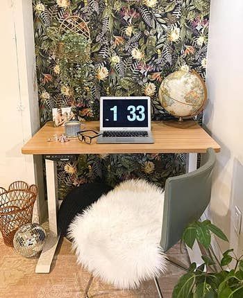a standing desk featuring a light wood finish in a home office setting