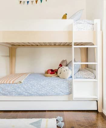 A trundle bunk bed in a child's room, featuring a convenient ladder for access.