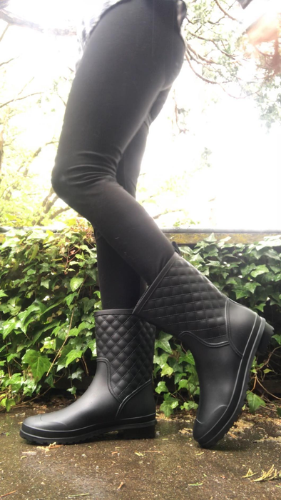 a reviewer showcasing black waterproof boots