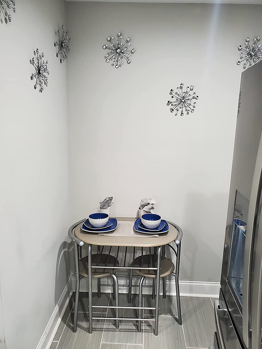 A reviewer's photo showcasing a silver bistro table with two matching chairs tucked neatly underneath