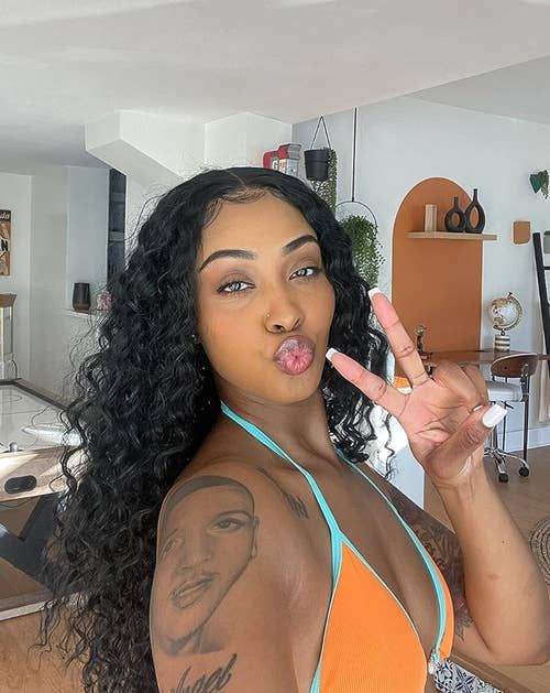 reviewer taking a selfie in a long black wavy wig