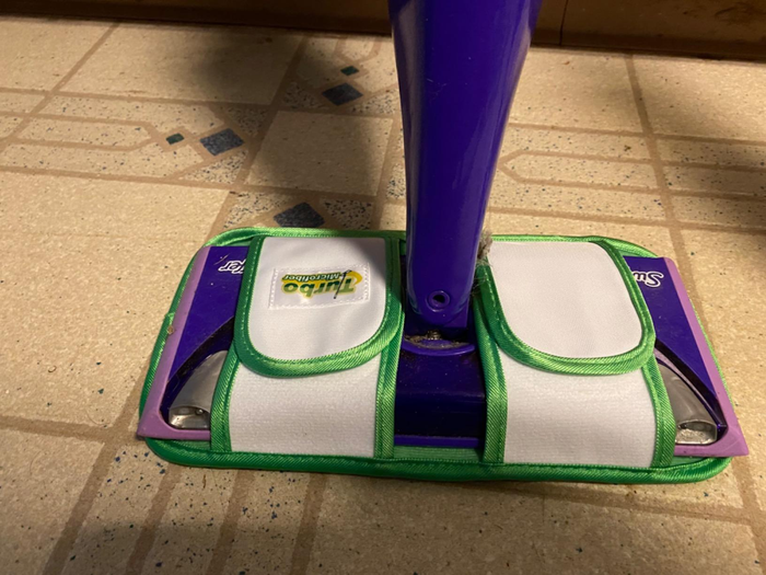 A reviewer's Swiffer fitted with the new microfiber pad.