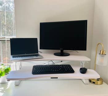 the standing desk converter supporting a monitor, laptop, and keyboard