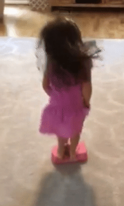 reviewer's child bouncing on the pink pogo jumper