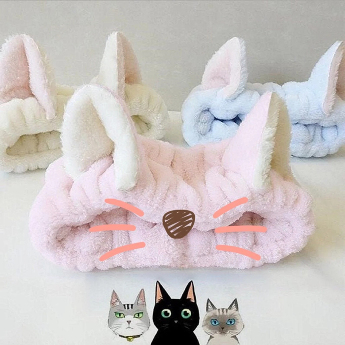 A trio of cat headbands in green, blue, and pink, with the pink one featuring adorable drawn-on cat nose and whiskers.
