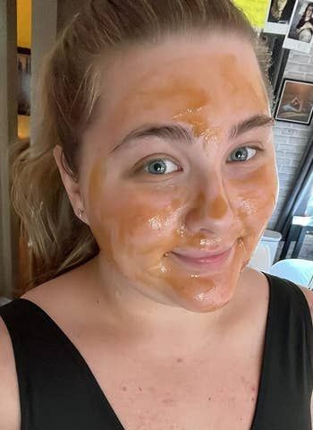 A person posing for a selfie while wearing a facial mask, dressed in a sleeveless top. The image is connected to skincare shopping.