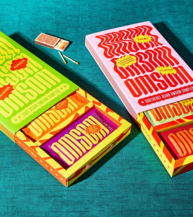 Two Omsom boxes filled with sauce packets, ready to elevate your cooking.
