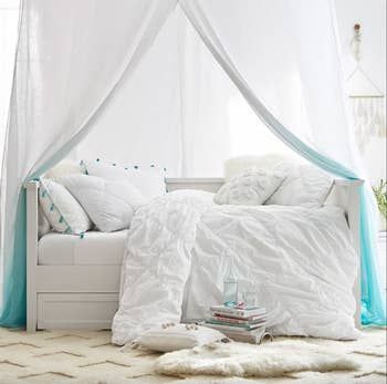 A white daybed with a trundle, blending simplicity and practicality for any room.