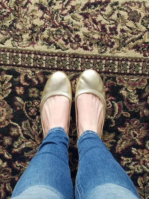 reviewer wearing the gold flats