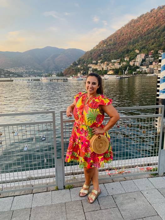 writer of the article wearing gold Birkenstocks with a vibrant dress while on vacation
