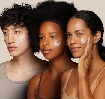 Three models applying moisturizer to their cheeks.