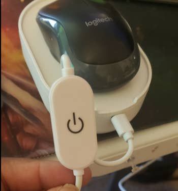 A reviewer showing the power button of the device.