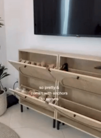 A model opening up the drawers and placing shoes inside.