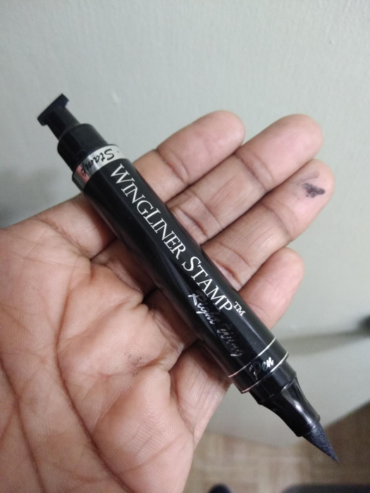 a user holding the eyeliner pen/stamp in hand