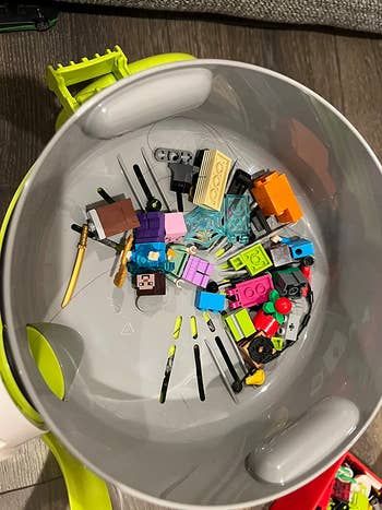 The inside of the vacuum showing small Lego pieces.