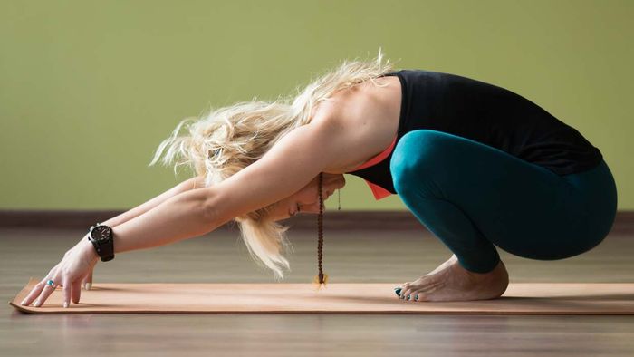 A yogi performing ankle stretches in a squat position