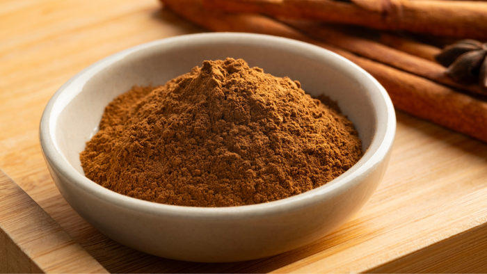 A close-up of a bowl filled with ground cinnamon.