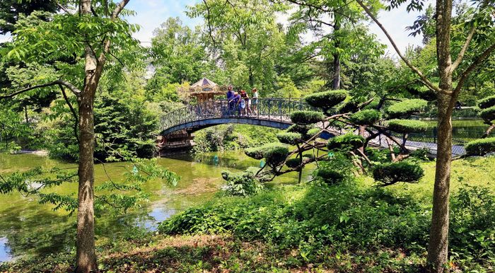 A family enjoying the view from a bridge in Bordeaux's Jardin Public