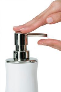A woman gently applies hydrating cream to her skin
