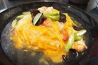 Phiên bản Nhật Bản, Tenshindon (tiếng Nhật: 天津丼), trứng ốp la với thịt cua trên cơm