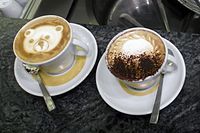 Hai tách cappuccino được trang trí theo các cách khác nhau.