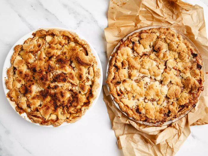 Aerial view of two apple pies, one baked in a brown paper bag and the other wrapped in parchment paper