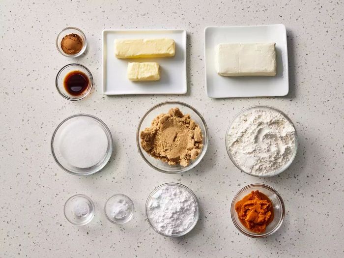 All the ingredients for making pumpkin cheesecake cookies neatly arranged on a kitchen counter.