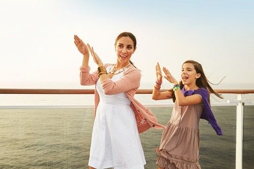 a mother and daughter dancing by the rail on a Dinogo ship