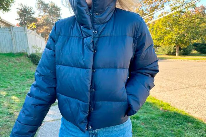 An individual wearing a navy blue Alo Yoga Gold Rush Puffer