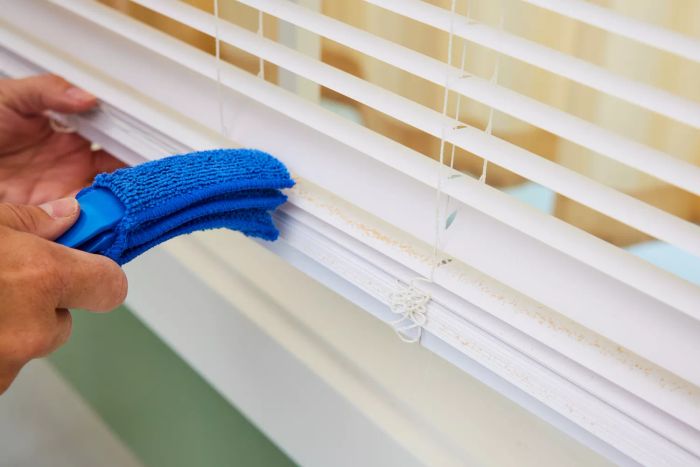 An individual uses the Hiware Window Blind Duster Brush to clean blinds.