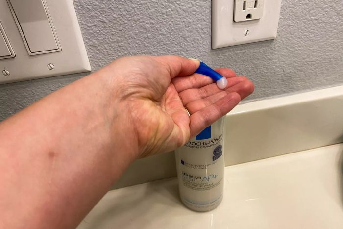 A person dispensing La Roche-Posay Lipikar Wash AP+ Moisturizing Body & Face Wash onto their hand