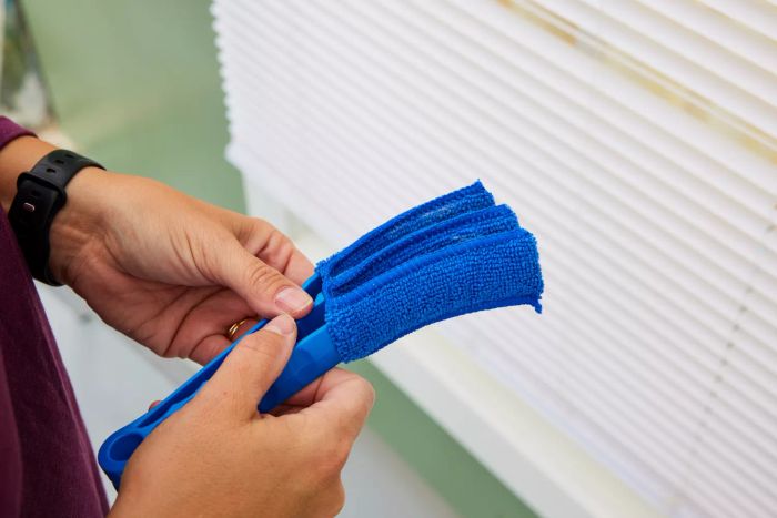 A person makes adjustments to the Hiware Window Blind Duster Brush.