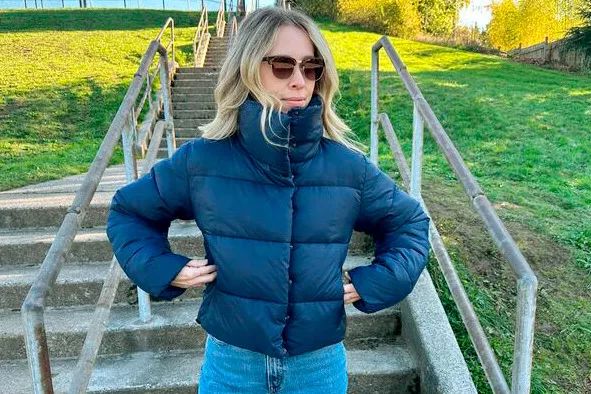 A woman sporting a navy blue Alo Yoga Gold Rush Puffer